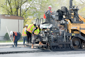 Paving machine and road crew install new asphalt on Main Street